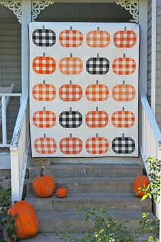 an orange and black pumpkin quilt on the steps