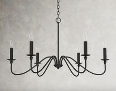 a black chandelier with five candles hanging from it