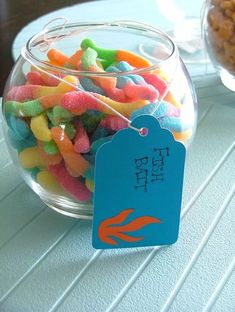 a glass bowl filled with colorful candy and a blue tag on the top that says pet sit