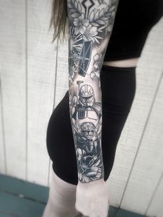 a woman's arm with tattoos on it, and flowers in the middle of her arm