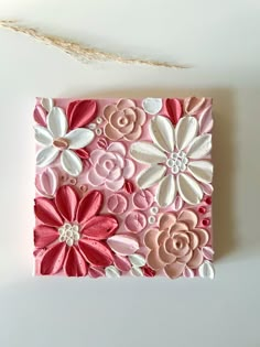 a pink and white flowered card on a string next to a piece of string