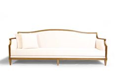 a white couch with two pillows on it's back and one arm in gold