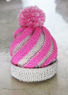 a pink and grey knitted hat sitting on top of a counter