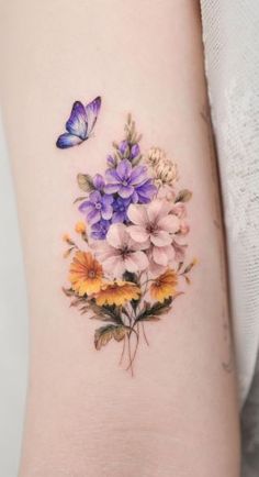 a woman's arm with flowers and butterflies on it