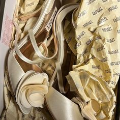 an open shoe box with several pairs of shoes in it and some papers on the floor