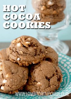 a stack of cookies sitting on top of a blue and white plate next to a glass vase