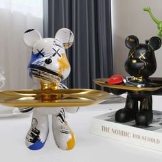 two small figurines are sitting on top of a table