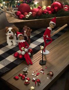 three elfs sitting on a table with christmas decorations