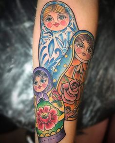 a woman's arm with an image of two women and a cat on it