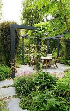 an outdoor dining area is surrounded by greenery