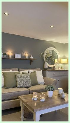 a living room filled with furniture and candles on the coffee table in front of it