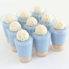 there are many desserts in small cups with white toppings on each one side