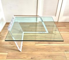 a glass table sitting on top of a hard wood floor