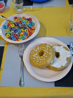 two donuts on plates with white frosting and sprinkles next to a bowl of cereal