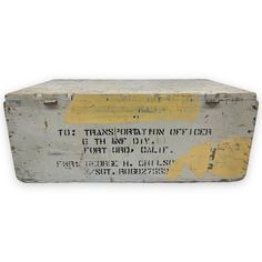 an old metal box with some writing on the front and bottom, sitting against a white background