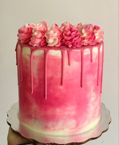 a pink and white cake with flowers on top