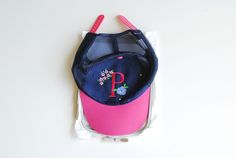 a pink and blue hat with the letter p on it