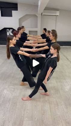 a group of people standing in a circle on top of a dance floor with their hands together