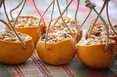 small oranges are wrapped in twine and decorated with nuts, seeds and other things