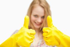 a woman in yellow gloves giving the thumbs up