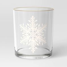 a clear glass with a white snowflake design on the side and gold rim