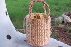 a woven bag sitting on top of a white bench