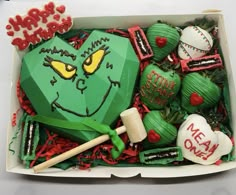 a box filled with lots of green and red decorations on top of a white table