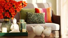 a living room filled with lots of furniture and flowers on top of a coffee table