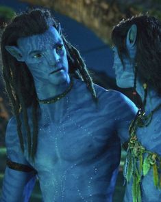 two people dressed in blue are standing next to each other and one has dreadlocks on his head