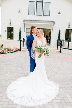 a bride and groom standing in front of a white building