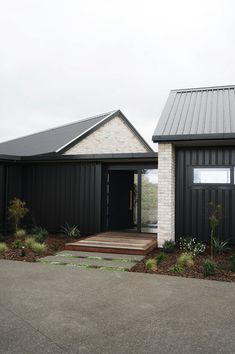 a black and white house with steps leading to the front door