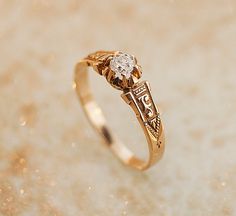 a close up of a gold ring with a diamond on it's center stone