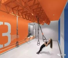 a woman is hanging upside down on a rope in an orange and white gym room