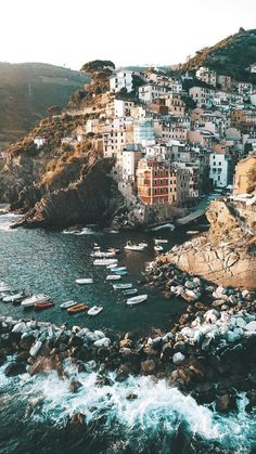 an aerial view of the ocean with boats in the water and buildings on the hillside