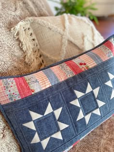 a blue and white pillow sitting on top of a couch