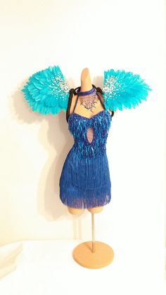 a mannequin wearing a blue dress with feathers on it