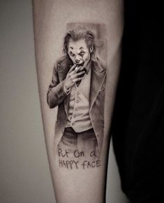 a joker tattoo on the arm with words put on a happy face written in black ink