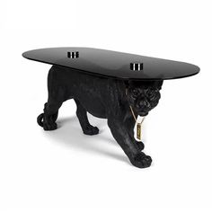 a black dog is standing underneath a glass table