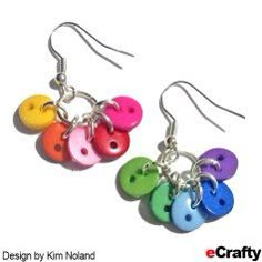 a pair of earrings with colorful buttons hanging from it's earwires on a white background