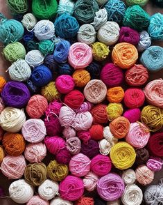 several skeins of multicolored yarn are arranged in rows on top of each other