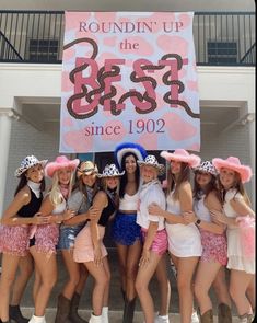 a group of women standing next to each other in front of a sign