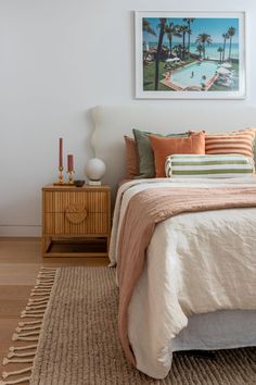 a bedroom with a bed, nightstand and pictures on the wall above it that is decorated in neutral colors