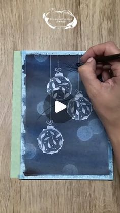 someone is drawing christmas ornaments on a piece of paper