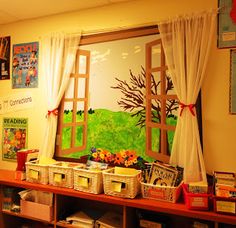 a room with many books and pictures on the wall, including an open window that shows a green field