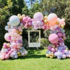 a bunch of balloons that are in the grass