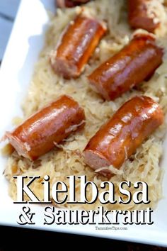 several sausages and sauerkraut sit on top of rice in a white dish