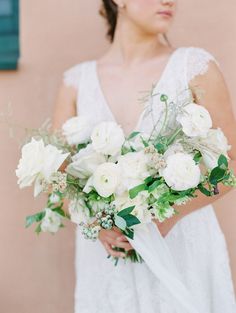 a woman holding a bouquet of white flowers