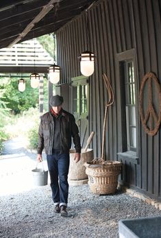 a man walking down a walkway carrying a bucket