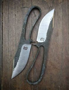 two pairs of scissors sitting on top of a wooden table