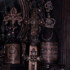 an assortment of antique bottles are displayed in front of a mirror and ornately decorated wall